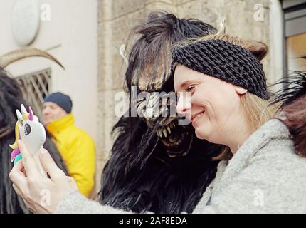 Monaco di Baviera, Germania - 8 dicembre 2019 donna assume un selfie con un interprete presso il tradizionale Krampus eseguire presso il mercato di Natale nel centro di Monaco di Baviera, demo Foto Stock