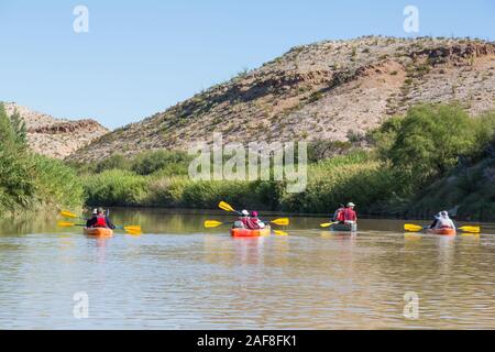 In canoa sul fiume Rio Grande, che scorre a nord-est nei pressi di Rio Grande villaggio, parco nazionale di Big Bend, Texas. Carrizo invasiva della canna da zucchero per le banche. Foto Stock