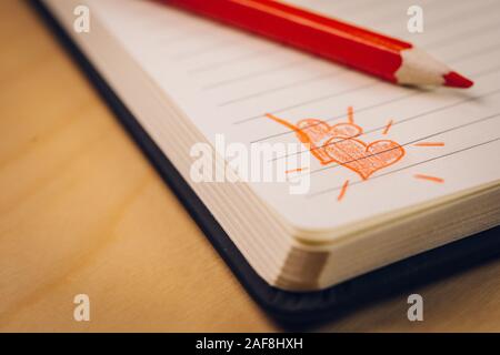 Amore cuori su notebook con la penna su un tavolo di legno Foto Stock