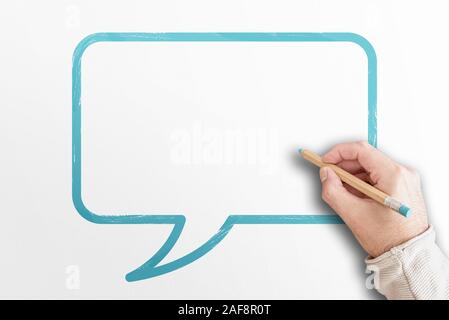 Mano che tiene la scrittura a matita in discorso bolla su sfondo bianco con spazio di copia Foto Stock