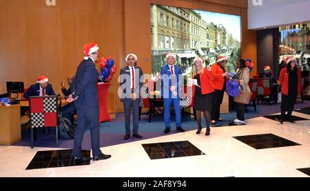 Il 13 dicembre 2019, Metro banca apre una nuova filiale in Market Street, Manchester, Regno Unito. Il personale indossare cappelli di Natale per accogliere i clienti. Foto Stock