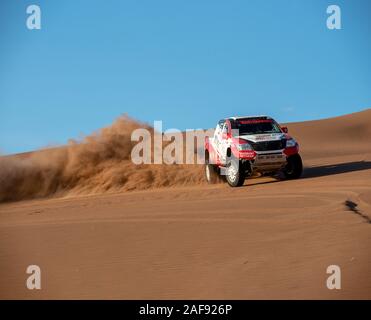 toyota hilux dakar rally edizione spruzzi di polvere quando si arrampica una duna di sabbia in dasht e lut o sahara deserto, ads spazio Foto Stock