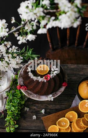 In casa bundt cake con fiori su un tavolo di legno. Foto Stock