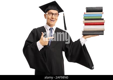 Senior uomo che indossa un abito di graduazione e titolari di una pila di libri isolati su sfondo bianco Foto Stock