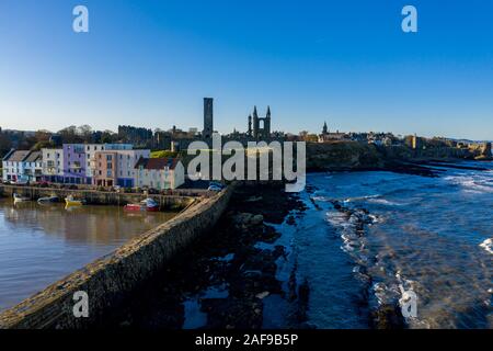 Vista unica del drone dal molo di St Andrews verso le rovine della cattedrale di St Andrews, Scozia con la costa drammatica vista sullo sfondo. Foto Stock