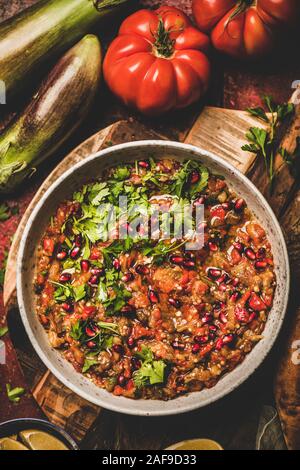 Bagno turco, Medio Oriente meze tradizionale motorino di avviamento. Piatto di laici Babaganoush immersione a freddo in una terrina condite con prezzemolo e i semi di melograno e limone su rustico Foto Stock