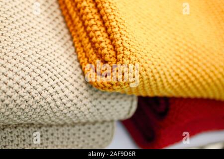 Rosso, beige e giallo coperte a maglia. Accogliente e calda nella stagione invernale. Foto Stock
