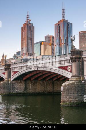 Melbourne, Australia - 17 Novembre 2009: Tramonto sulla parte di Princes ponte sull' acqua scura nel fiume Yarra con gruppo di grattacieli om indietro. Foto Stock