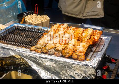 Seoul, Corea del Sud - 6 Dicembre 2019: a Myeongdong district a sera, il popolare sito per trattamenti estetici e di bellezza e negozi di cibo di strada. Foto Stock