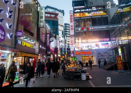 Seoul, Corea del Sud - 6 Dicembre 2019: a Myeongdong district a sera, il popolare sito per trattamenti estetici e di bellezza e negozi di cibo di strada. Foto Stock