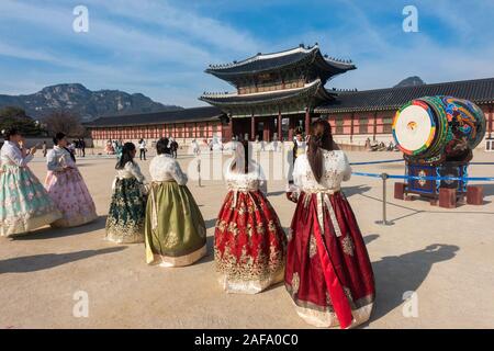 Seoul, Corea del Sud - Novembre 28th, 2019: turisti indossando il tradizionale coreano Hanbok dress e visitando il Palazzo Gyeongbokgung su una soleggiata giornata invernale Foto Stock