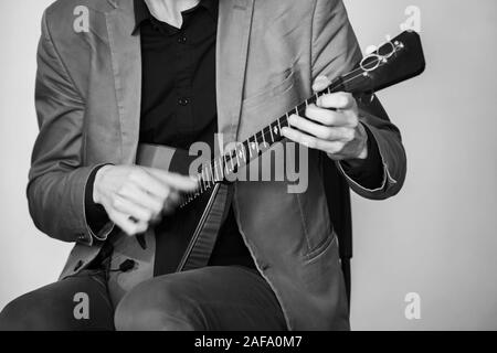 L'uomo gioca la balalaika. Close-up stilizzato retrò foto in bianco e nero Foto Stock