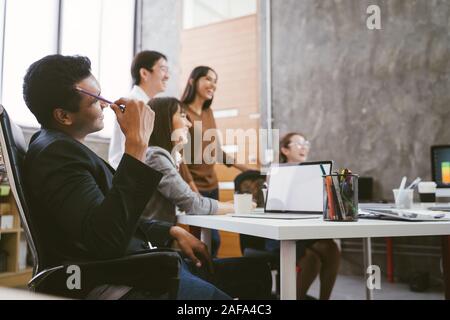 Gruppo di felice team asiatico azienda creativa persone ridere in riunione. Il lavoro di squadra concetto Foto Stock