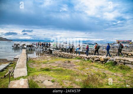 Copacabana, Bolivia-Jan 4, 2019: turisti andando per le barche nel porto della piccola cittadina turistica di Copacabana in una baia del Lago Titicaca, Bolivia Foto Stock