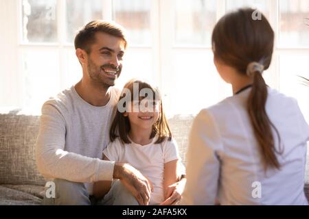 Sorridente padre e figlia piccola visita medico pediatra insieme Foto Stock