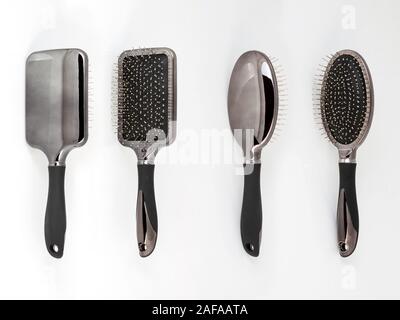 Impostare metallico di spazzole per capelli pettini di colore differenti isolati. Primo piano di una nuova ed elegante moderno spazzola per capelli in due viste. Foto macro della parte anteriore e posteriore vi Foto Stock