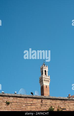 La Torre del Mangia e scooter parcheggiato parzialmente nascosto nel sito patrimonio mondiale dell'UNESCO di Siena, Toscana, Italia EU Foto Stock