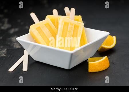 Orange Popsicles (messa a fuoco selettiva; close-up shot) su un sfondo vintage Foto Stock