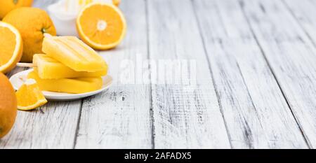 Orange Popsicles (messa a fuoco selettiva; close-up shot) su un sfondo vintage Foto Stock