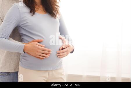 Amorevole marito teneramente toccando a sua moglie il ventre Foto Stock