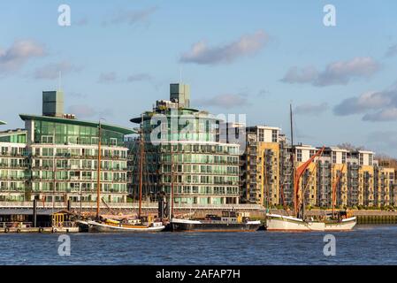 Historic imbarcazioni ormeggiate presso l'Eremo ormeggi comunitario con il moderno sviluppo appartamenti, Wapping, London, Regno Unito Foto Stock