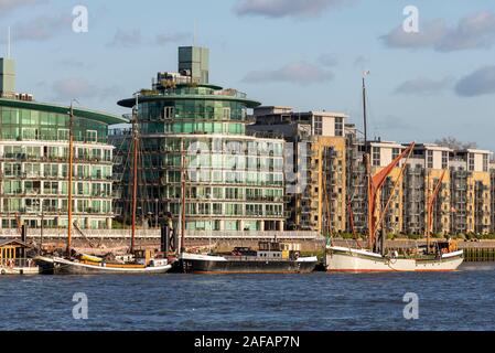 Historic imbarcazioni ormeggiate presso l'Eremo ormeggi comunitario con il moderno sviluppo appartamenti, Wapping, London, Regno Unito Foto Stock