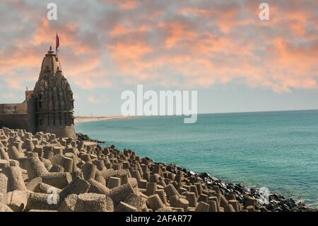 Lone tempio indù con bandiera sul mare Arabico costa con interruttori di onda Foto Stock