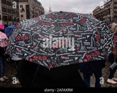 Berlino, Germania. Xiv Dic, 2019. Una donna stessa protegge dalla pioggia con un ombrello sulla Pariser Platz. Credito: Paolo Zinken/dpa/Alamy Live News Foto Stock