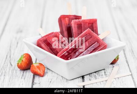 In casa Strawberry Popsicles (close-up shot; messa a fuoco selettiva) su sfondo vintage Foto Stock