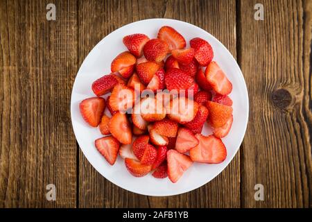 Fatta fresca fragole tagliate su un sfondo vintage come dettagliato di close-up shot Foto Stock