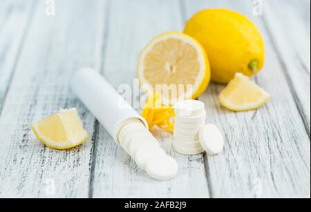 Compresse di vitamina C come dettagliato alta close-up shot su un vintage tavolo in legno; il fuoco selettivo Foto Stock