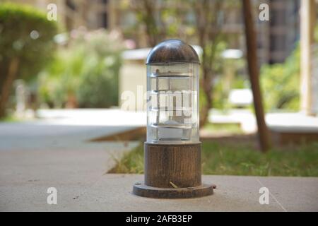 Insieme di lampade in legno su un terreno elevato . piccola lanterna in un giardino sulla terra . Massa illuminazione strada lampada montata su un prato verde in un parco . Foto Stock