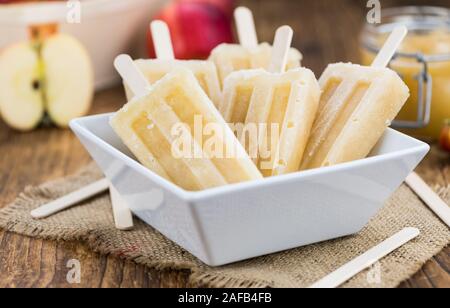 Apple Popsicles su un vecchio tavolo di legno (close-up shot; messa a fuoco selettiva) Foto Stock
