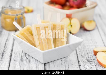 Apple Popsicles su un vecchio tavolo di legno (close-up shot; messa a fuoco selettiva) Foto Stock