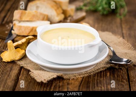 Chanterelle zuppa come dettagliato alta close-up shot su un vintage tavolo in legno; il fuoco selettivo Foto Stock