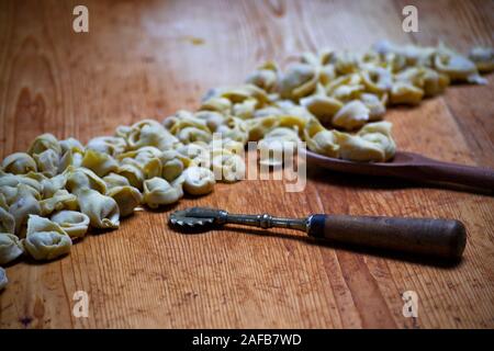 Fatte a mano e tortellini fatti in casa su di un legno scheda chopper. Prodotti tipici di Modena e Bologna, Emilia Romagna, Italia. Cibo tradizionale Foto Stock