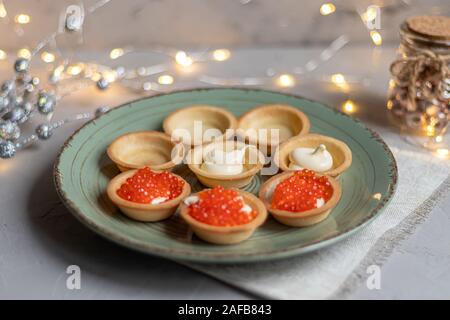 Pasticcini con formaggio a pasta morbida, gamberi e caviale rosso. Holiday piatto. Su una piastra verde. Foto Stock