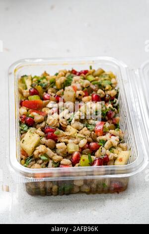 Instant Take Away sana insalata con grano, lenticchia, i semi di melograno, sottaceti e fette di pere in scatola di plastica / confezione contenitore. Alimenti biologici. Foto Stock