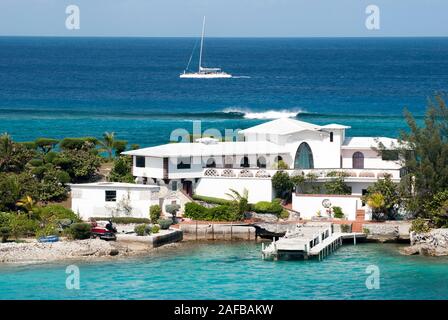 La bianca casa residenziale costruito su una stretta striscia di terra di Paradise Island tra il Mar dei Caraibi e il porto di Nassau (Bahamas). Foto Stock