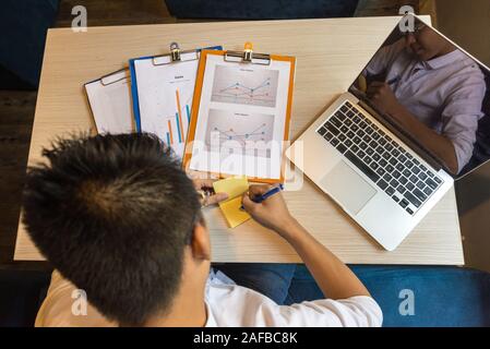 Elevato angolo di visione dell uomo asiatico scrivere una nota adesiva Foto Stock