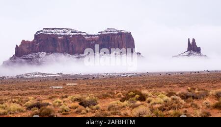 Nuvole basse si stanno insinuando a oscurare a doppio spiovente e il re sul trono in Monument Valley Navajo Tribal Park Foto Stock