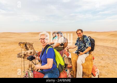 Africa, Egitto, al Cairo. Altopiano di Giza. Il 3 ottobre 2018. I turisti a cavallo di cammelli vicino le grandi piramidi di Giza. Foto Stock