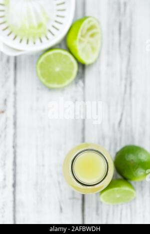 Di succo di lime fresco come dettagliato alta close-up shot su un vintage tavolo in legno (messa a fuoco selettiva) Foto Stock