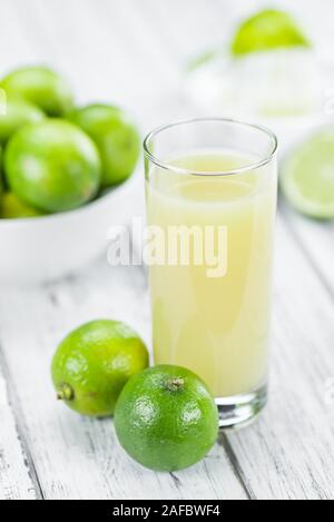 Di succo di lime fresco come dettagliato alta close-up shot su un vintage tavolo in legno (messa a fuoco selettiva) Foto Stock