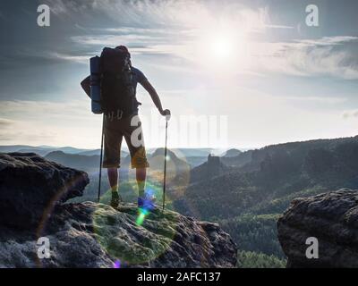 Escursionista tenere trekking bastoni per il nordic walking e il respiro profondo in corrispondenza del bordo. Foto Stock