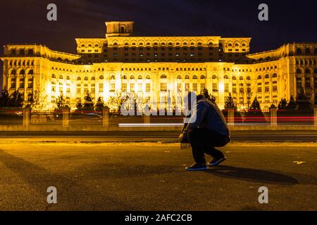 Uomo in piedi di fronte al Palazzo del Parlamento di Bucarest, Romania, 2019 Foto Stock