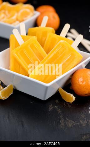 Porzione di freschi fatti in casa Popsicles mandarino (close-up shot; messa a fuoco selettiva) su un sfondo vintage Foto Stock