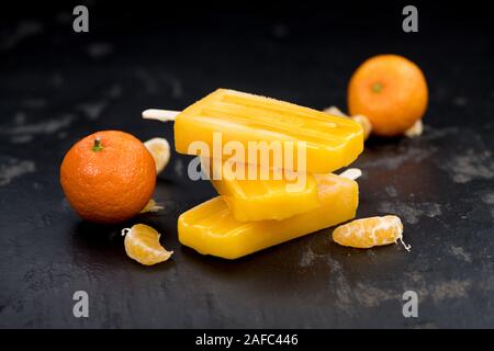 Porzione di freschi fatti in casa Popsicles mandarino (close-up shot; messa a fuoco selettiva) su un sfondo vintage Foto Stock