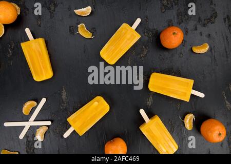 Porzione di freschi fatti in casa Popsicles mandarino (close-up shot; messa a fuoco selettiva) su un sfondo vintage Foto Stock