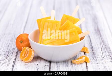 Porzione di freschi fatti in casa Popsicles mandarino (close-up shot; messa a fuoco selettiva) su un sfondo vintage Foto Stock
